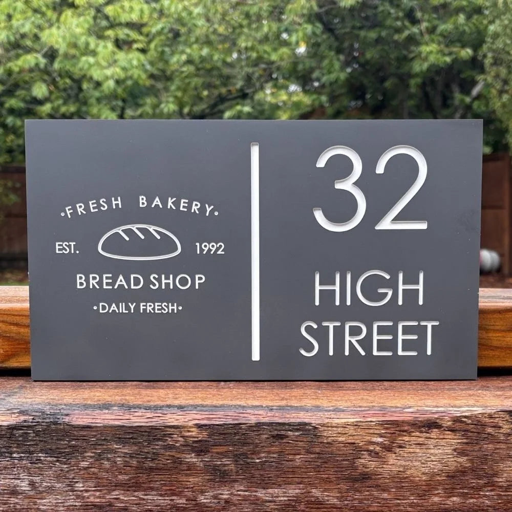 Sign for a bakery with text and number on a wooden surface