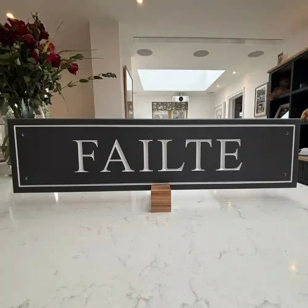Decorative sign with 'FAILTE' on a marble surface in an indoor setting