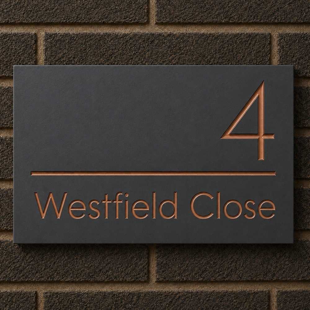 A rectangular slate house number sign mounted on a dark brick wall. The sign features the number 4 in a copper-toned outline above the words 'Westfield Close' in matching copper lettering, separated by a horizontal line.