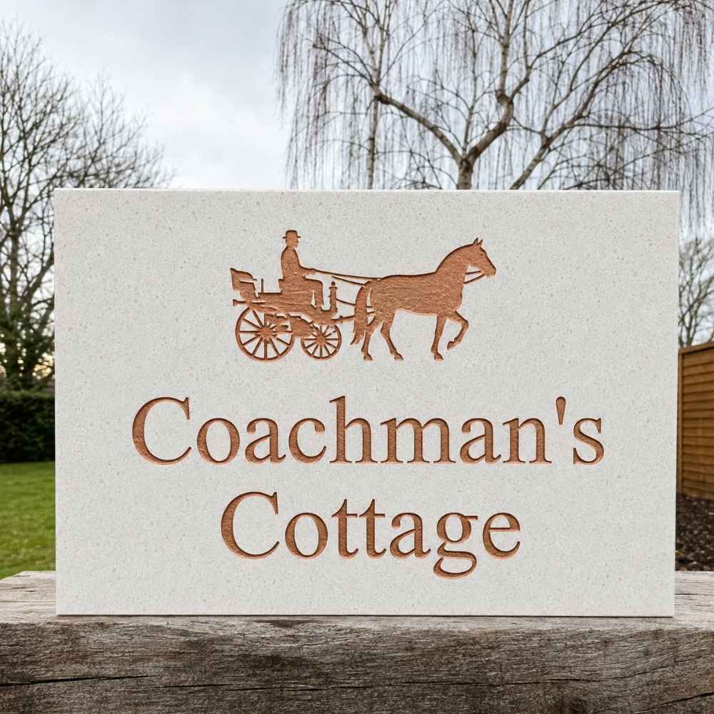 A rectangular quartz stone or concrete sign with a laser-cut design of a horse-drawn carriage and the words 'Coachman's Cottage' in a matching warm brown tone, displayed outdoors on a wooden post with trees and grass in the background.
