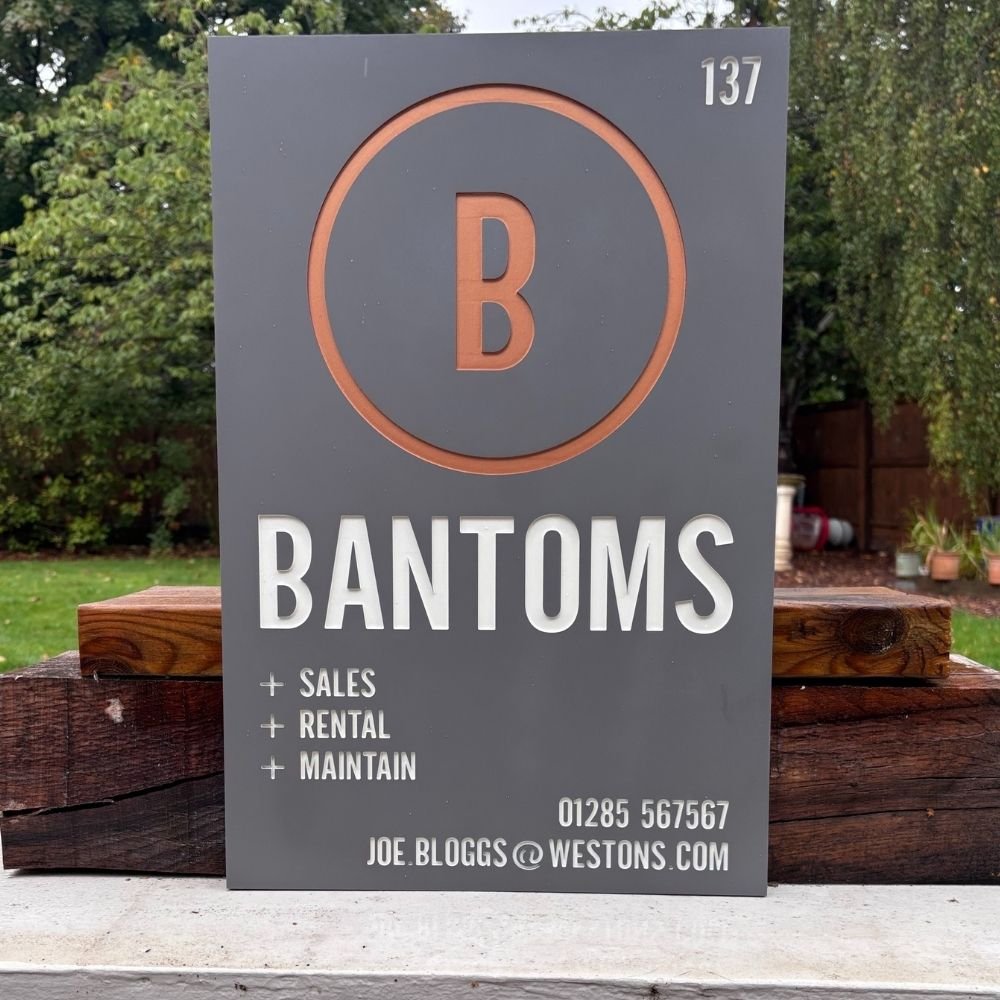 Bantoms sign with contact information on a wooden surface outdoors