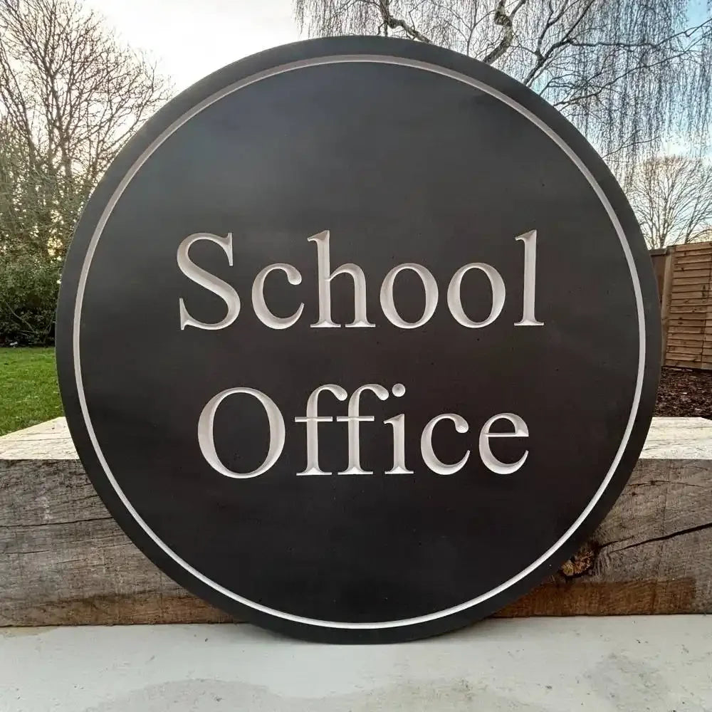 Round sign with 'School Office' text on a wooden background