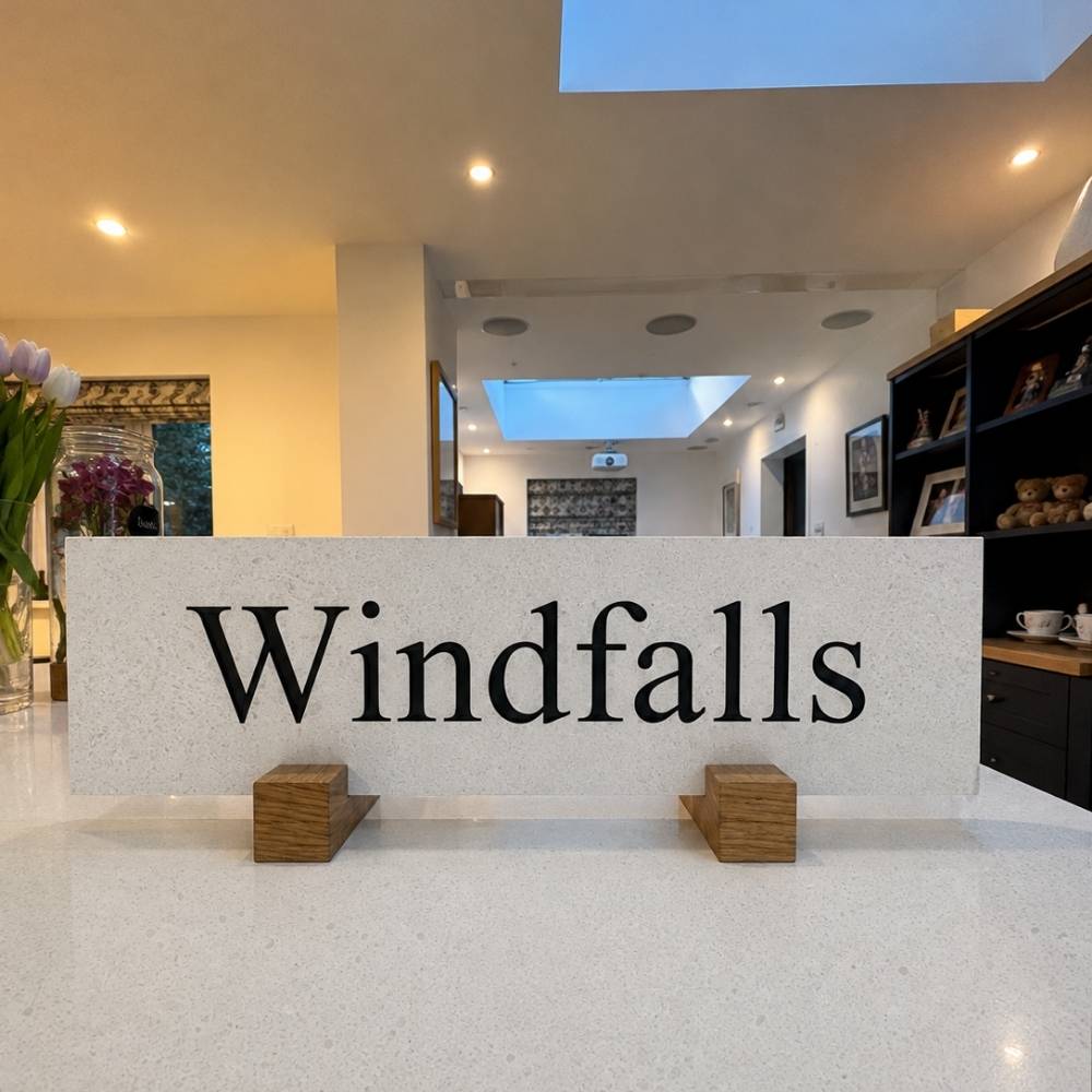 A horizontal quartz plaque reading 'Windfalls' in black serif lettering.
