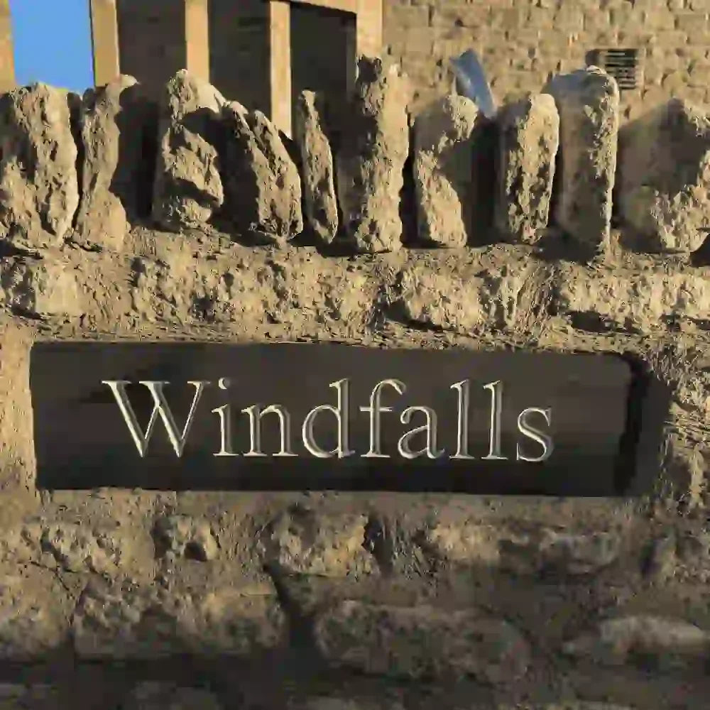 Decorative stone wall with a sign reading 'Windfalls'.