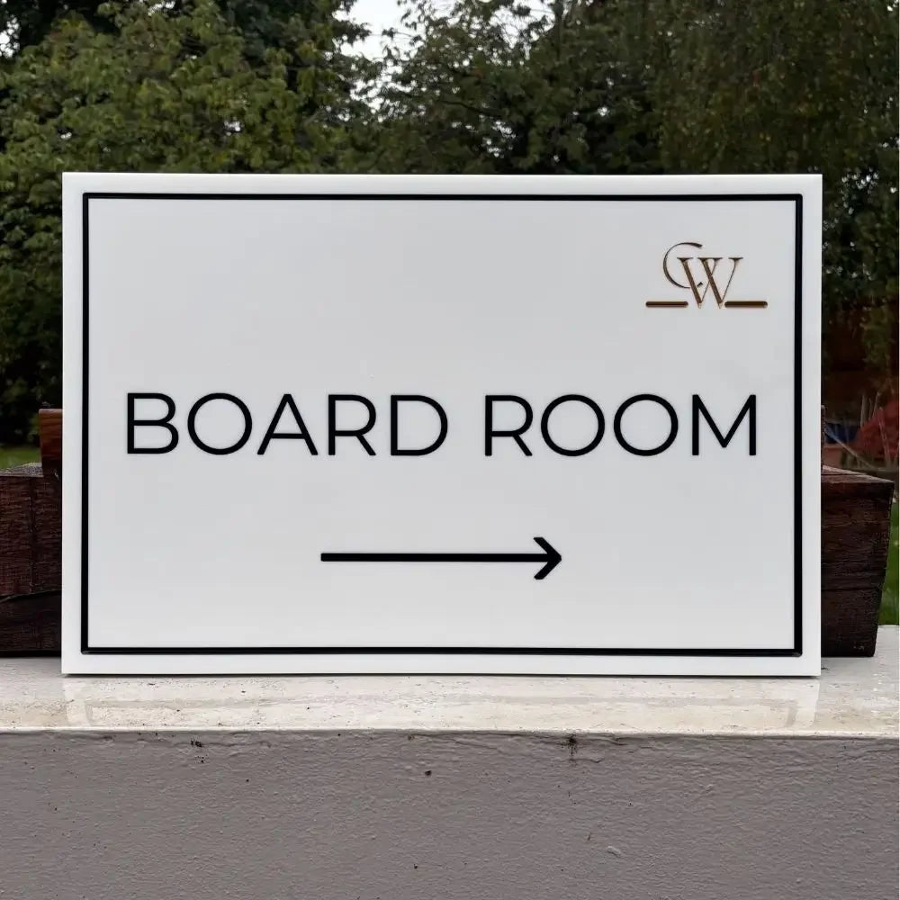Sign pointing to 'Board Room' with a logo in the corner, outdoors.