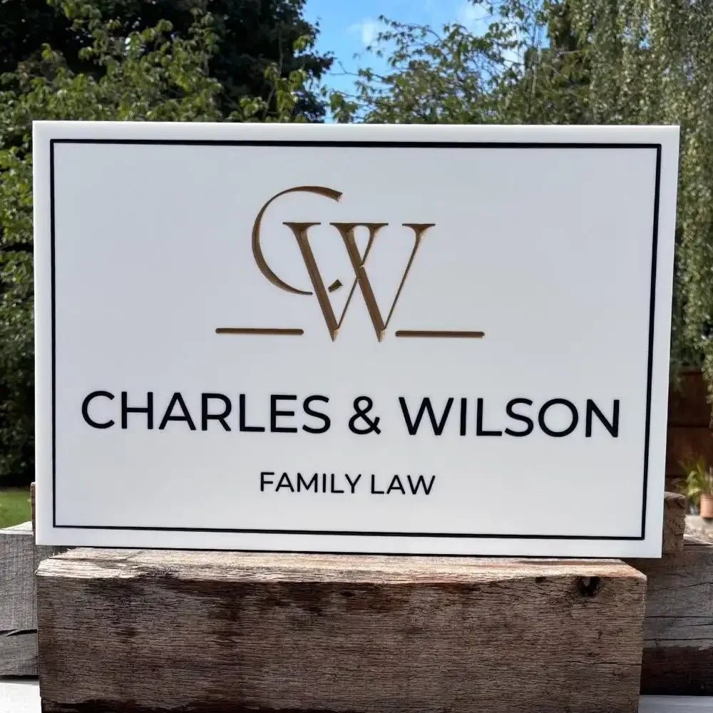 Sign for Charles & Wilson Family Law with logo on a wooden surface outdoors