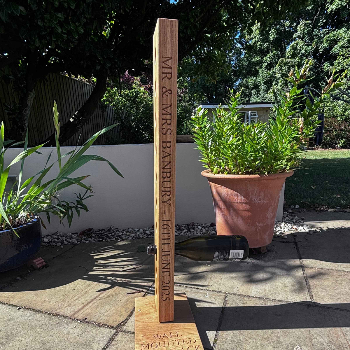 Wooden post with engraved text in a garden setting