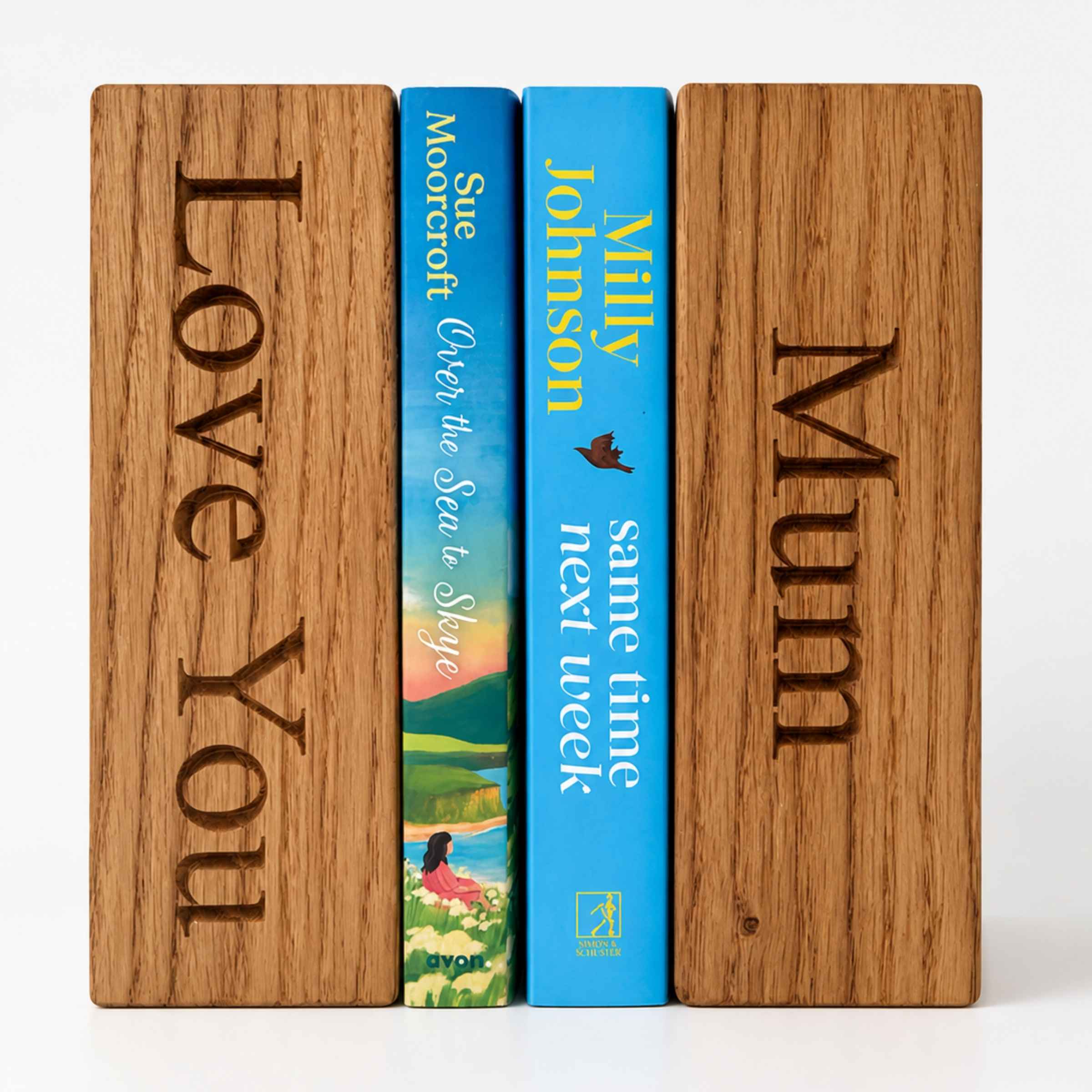 Two wooden bookends with engraved text and two books between them on a white background.