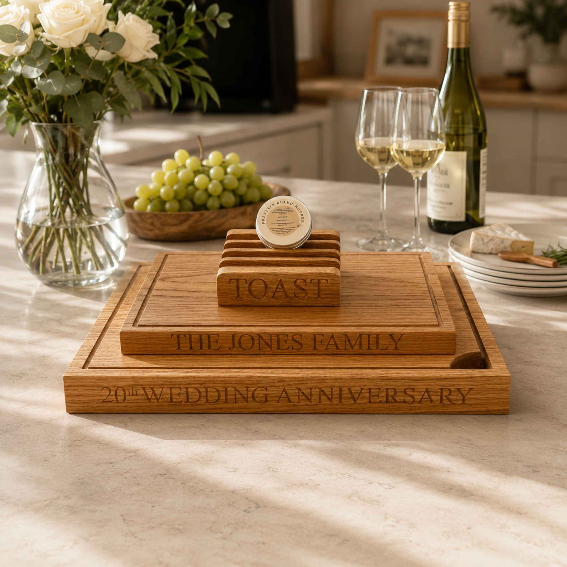 Wooden cutting board set with engraved text on a table with wine and grapes.