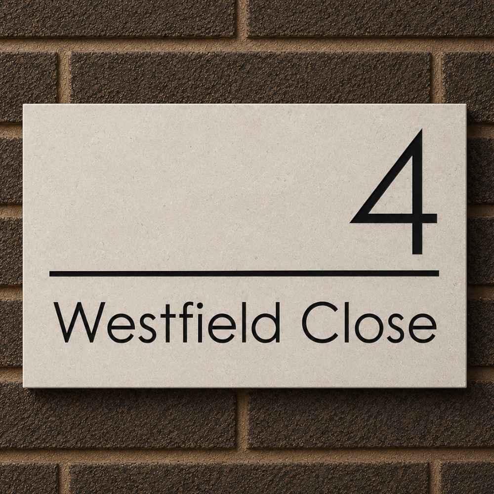 A rectangular limestone house number sign reading '4 Westfield Close' in black text, mounted against a dark brown brick wall.