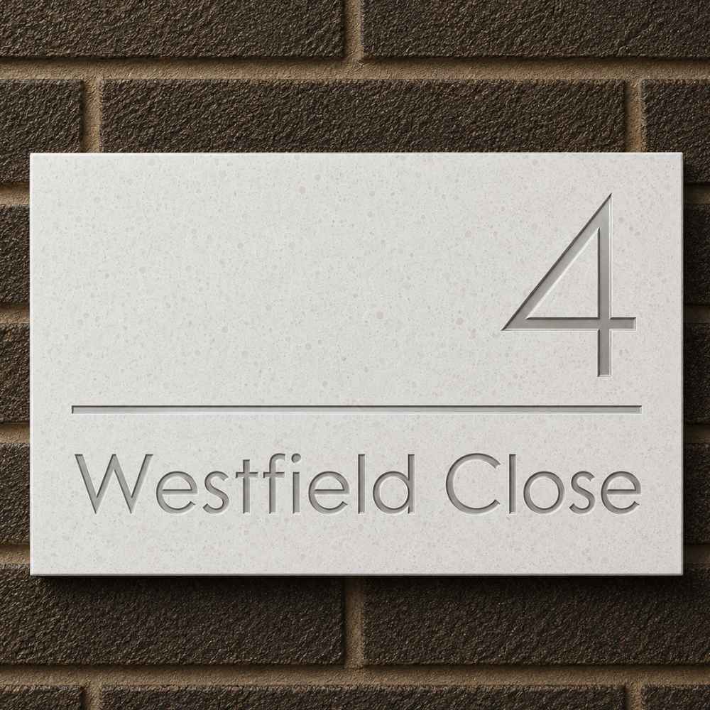 A rectangular quartz stone or concrete house number plaque mounted on a dark brown brick wall, featuring the number 4 and the address Westfield Close in raised gray lettering.