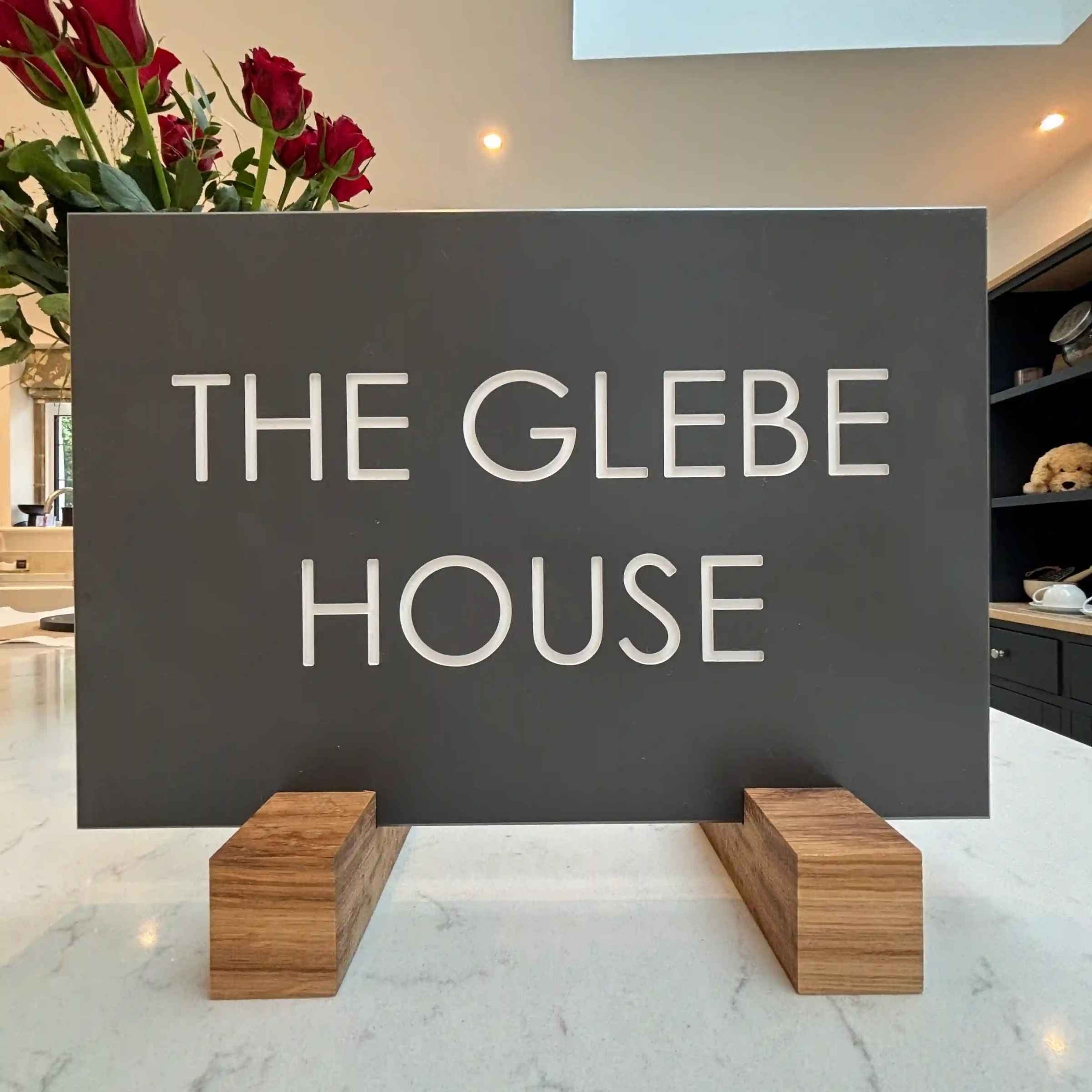 Rectangle Dark Slate sign with 'The Glebe House' text on a stand in a room with flowers and furniture.