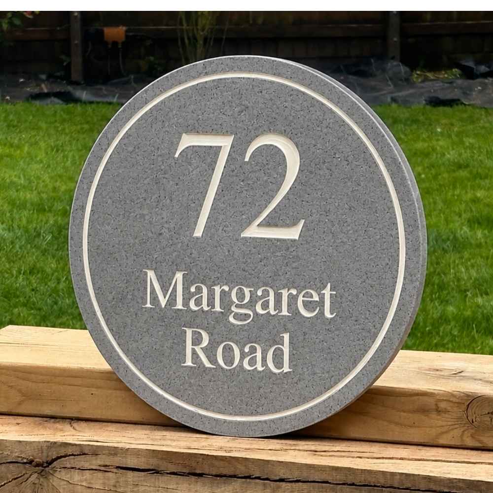 A round granite stone house number plaque reading '72 Margaret Road' in white lettering, 