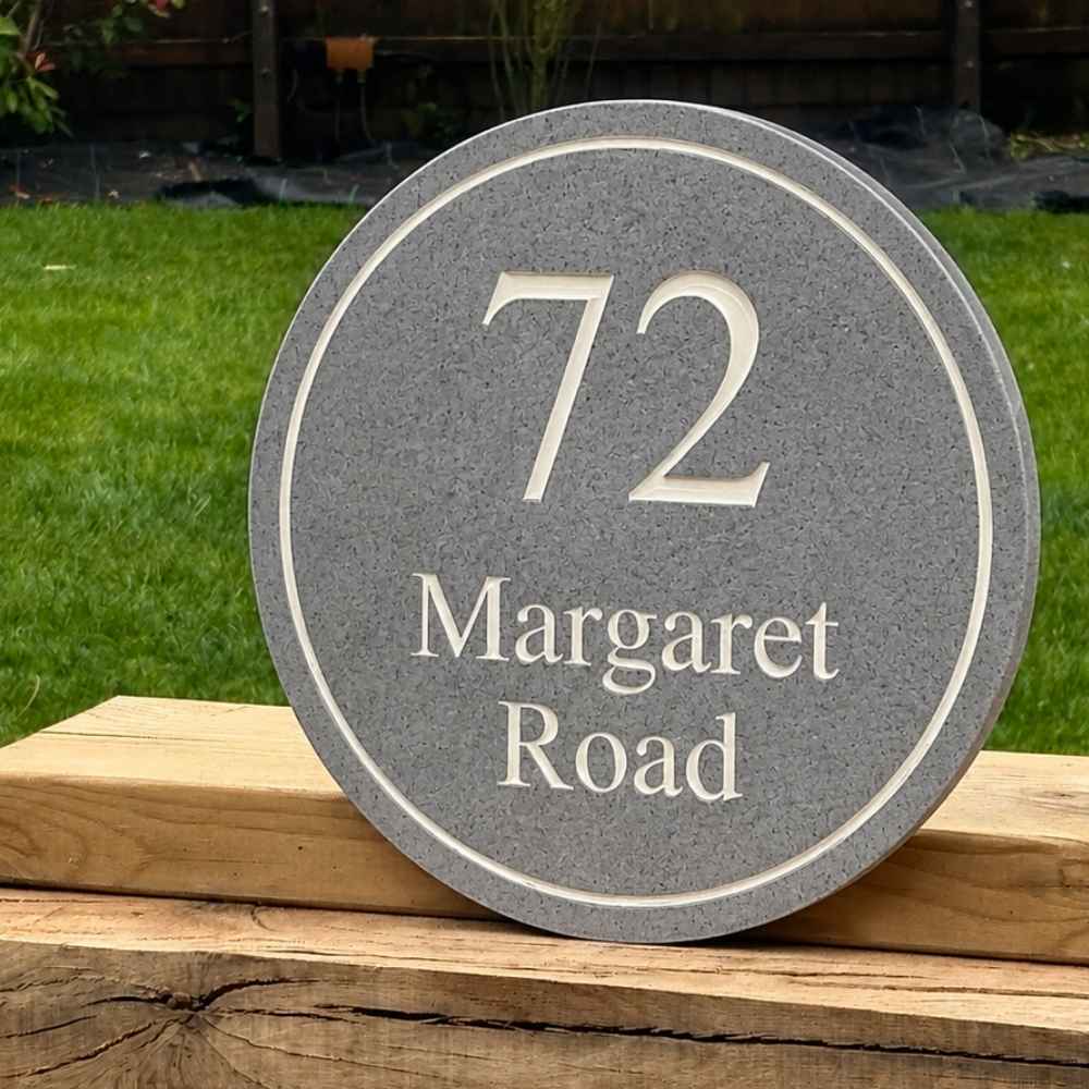 A round granite  house number plaque with the text '72 Margaret Road' in white.