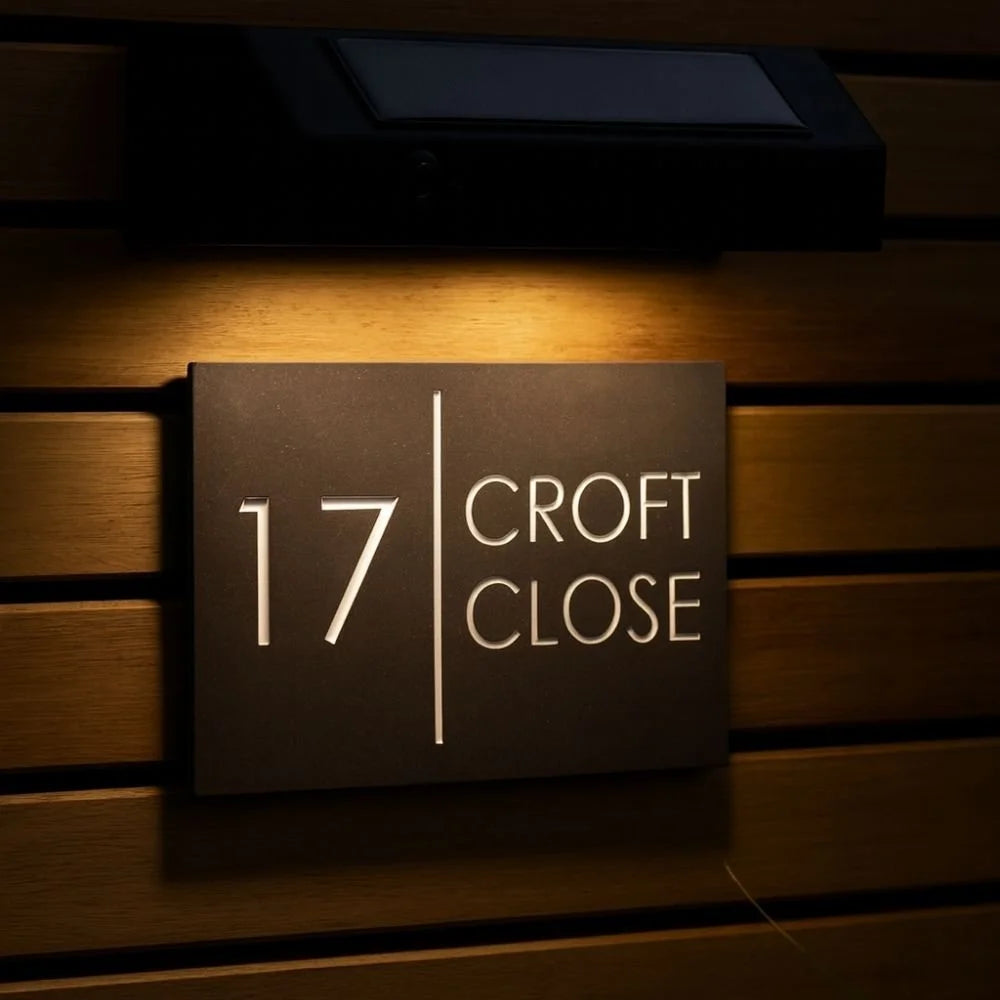 House number sign '17 Croft Close' illuminated on a wooden wall.