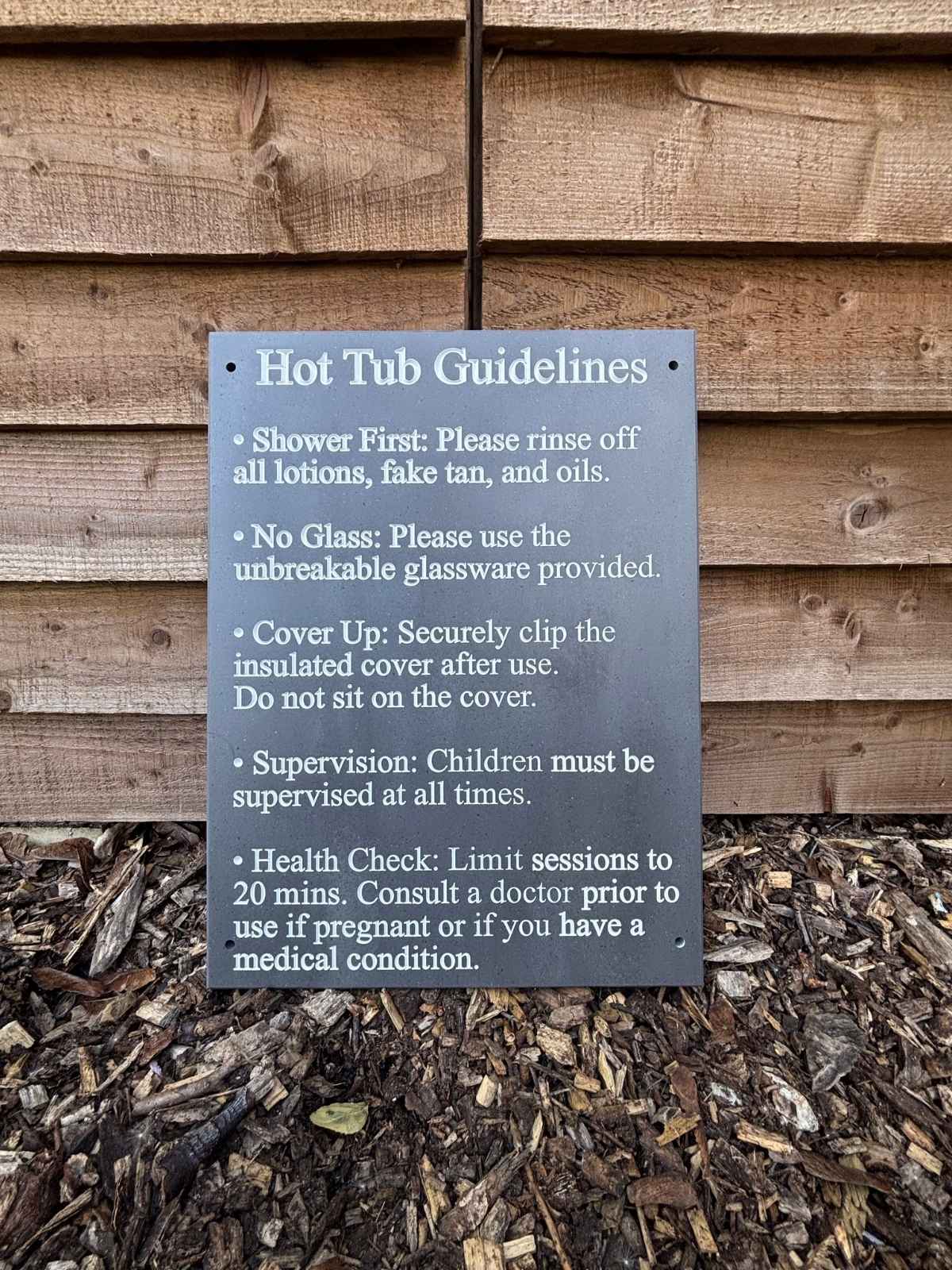 Hot tub guidelines sign on a wooden wall